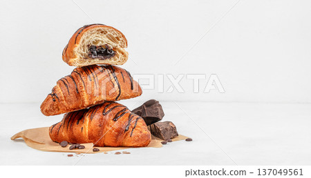 Stack of chocolate croissants with filling on light background Stack of chocolate croissants with filling on light background 137049561