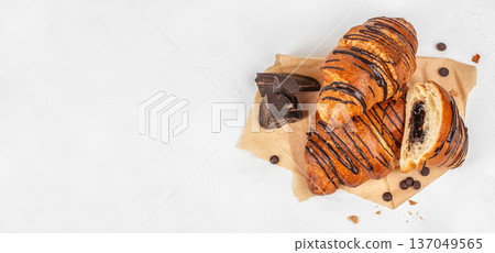 Top view chocolate croissants with dark chocolate on parchment Top view chocolate croissants with dark chocolate on parchment 137049565