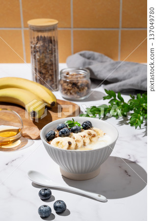 Greek yogurt with granola, blueberry and banana in a bowl on a marble table Greek yogurt with granola, blueberry and banana in a bowl on a marble table 137049780