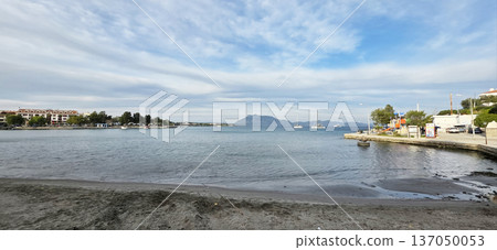 Scenic waterfront view with boats and mountains under cloudy sky Scenic waterfront view with boats and mountains under cloudy sky 137050053