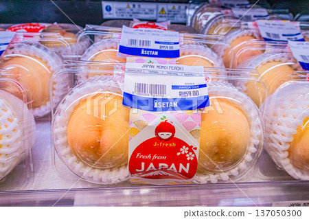 Kuala Lumpur, Malaysia - July 31, 2025: Fresh Japanese peaches in packaging at Isetan supermarket display 137050300