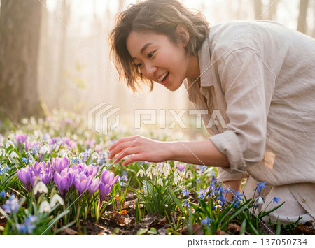 Young asian woman admiring spring flowers in sunny forest 137050734