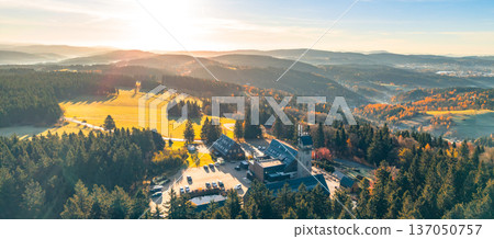 The Kralovka Lookout Tower offers stunning views of the Jizera Mountains in Czechia. Fall colors paint the landscape as sunlight illuminates the serene surroundings. 137050757