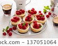 Mini cheesecakes topped with fresh raspberries on a serving plate 137051064