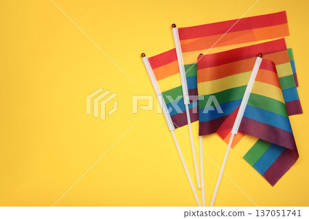 LGBT rainbow flag flat lay on yellow background. Space for text LGBT rainbow flag flat lay on yellow background. Space for text 137051741