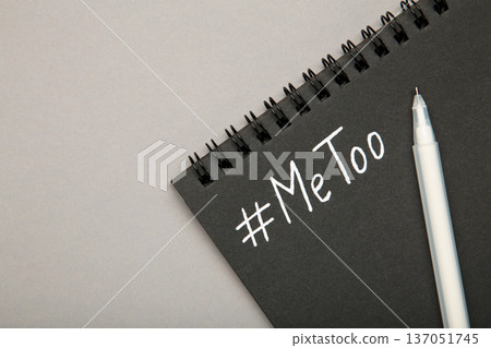 Hashtag METOO inscription white pen on black notebook on grey. Space for text 137051745