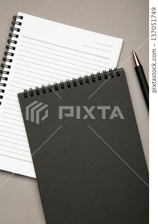 White and black spiral notebooks mockup on grey background. White and black spiral notebooks mockup on grey background. 137051749