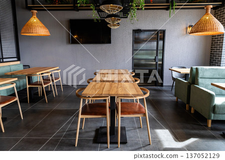 Contemporary restaurant interior with wooden tables and modern cozy dining area 137052129