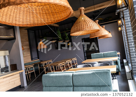 Stylish modern restaurant interior with wooden tables and rattan pendant lighting 137052132