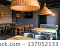 Stylish modern restaurant interior with wooden tables and rattan pendant lighting 137052133