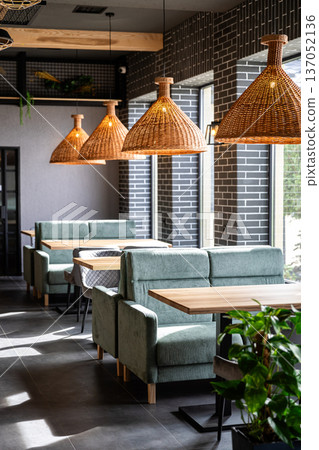 Modern cafe interior with cozy booths and rattan pendant lights in daylight 137052136