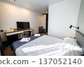 Cozy modern hotel bedroom with double bed fresh towels and soft natural window light 137052140