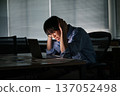 一位年輕的商人經常加班到深夜，卻仍無法完成工作。 137052498