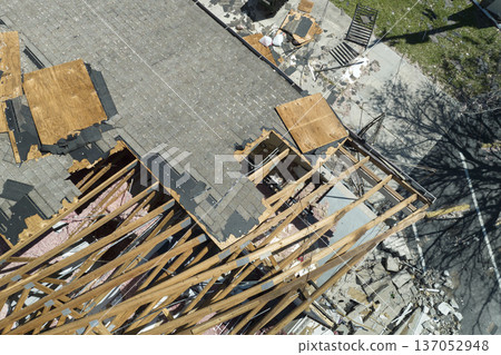 Wind damaged house roof with missing asphalt shingles after hurricane Ian in Florida. Repair of home rooftop concept Wind damaged house roof with missing asphalt shingles after hurricane Ian in Florida. Repair of home rooftop concept 137052948