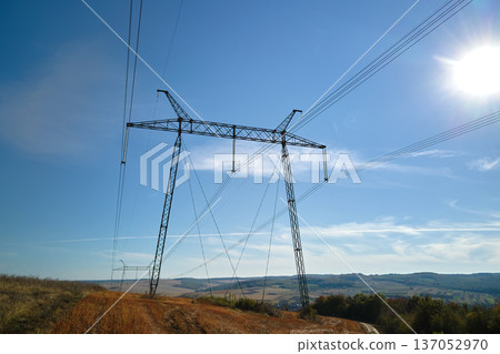 High voltage tower with electric power lines transfening electrical energy through cable wires 137052970