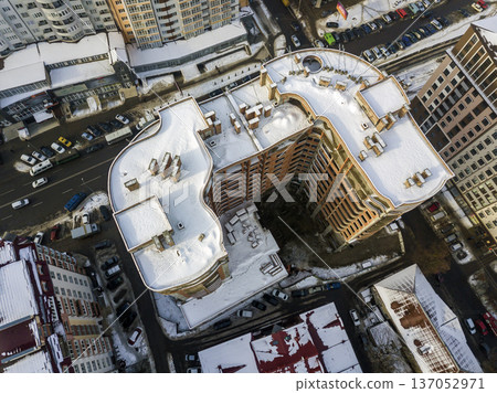 Aerial black and white winter panoramic top view of modern city with tall apartment complex buildings snowy roof, parked and moving cars along streets. Urban infrastructure, view from above. 137052971