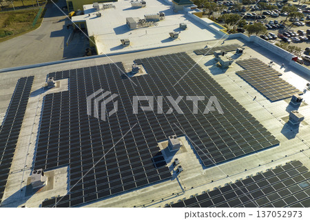 Aerial view of solar power plant with blue photovoltaic panels mounted on industrial building roof for producing green ecological electricity. Production of sustainable energy concept Aerial view of solar power plant with blue photovoltaic panels mounted on industrial building roof for producing green ecological electricity. Production of sustainable energy concept 137052973