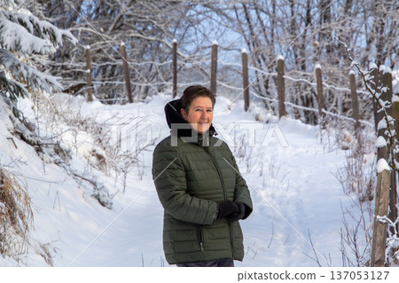 Woman walking in the snowy mountains looking at the camera Woman walking in the snowy mountains looking at the camera 137053127