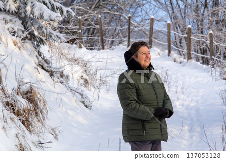 Woman walking in the snowy mountains looking at the camera Woman walking in the snowy mountains looking at the camera 137053128
