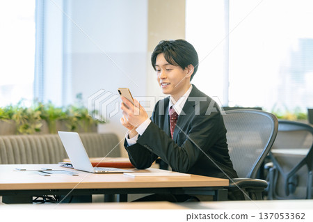 一個在辦公室使用智能手機的商人 137053362