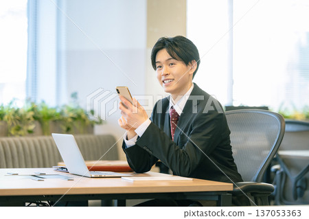 一個在辦公室使用智能手機的商人 137053363