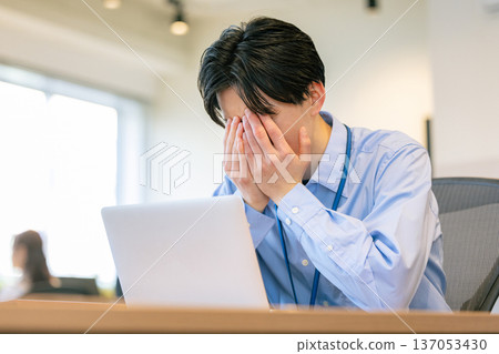 Businessman holding his head while looking at a computer screen 137053430