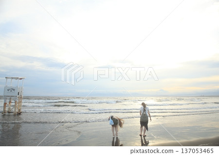 people walking on the beach at sunset people walking on the beach at sunset 137053465