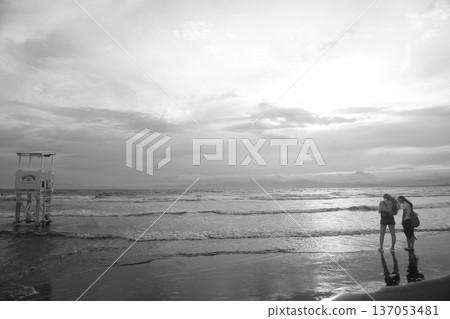 日落時人們在海灘上散步 日落時人們在海灘上散步 137053481