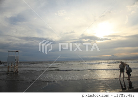 日落時人們在海灘上散步 日落時人們在海灘上散步 137053482