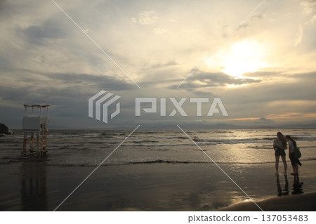 日落時人們在海灘上散步 日落時人們在海灘上散步 137053483