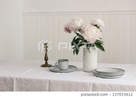 Minimal Dining Table Setting. Pink Peonies in Vase. Spring kitchen dinning room still life. Neutral Scandinavian Interior. Ceramic Plates, old candleholder. Cup of tea, Coffee. Elegant Home Decor. Minimal Dining Table Setting. Pink Peonies in Vase. Spring kitchen dinning room still life. Neutral Scandinavian Interior. Ceramic Plates, old candleholder. Cup of tea, Coffee. Elegant Home Decor. 137053612