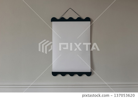Blank vertical scalloped poster mockup hanging on neutral beige wall. Black wooden picture frame. Empty white canvas display copy space. Scandinavian interior home decor. Artwork presentation template 137053620