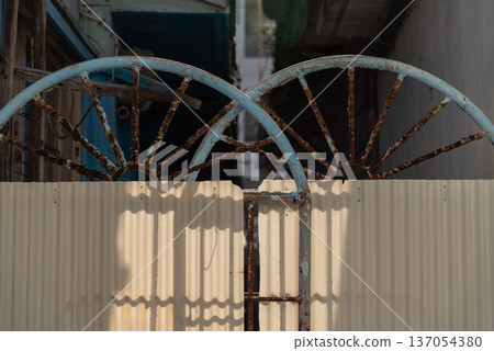 一扇老舊生鏽的鐵門，外覆波紋鐵皮。 137054380