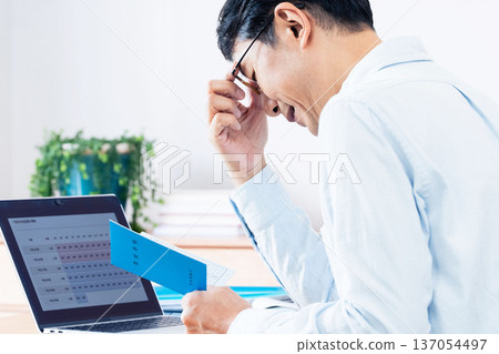 A middle-aged man thinking while looking at his pension book 137054497
