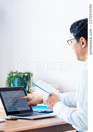 A middle-aged man thinking while looking at his pension book 137054500