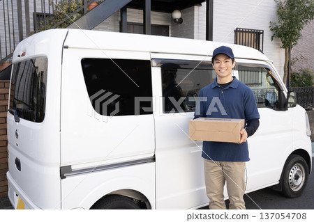 Smiling courier man delivering a package 137054708