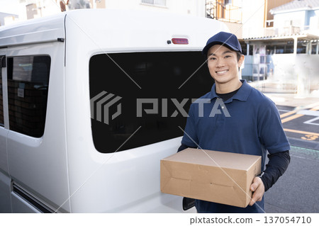 Smiling courier man delivering a package 137054710