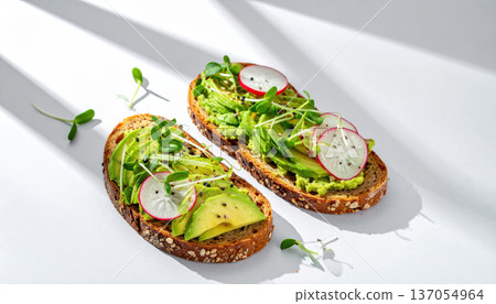 Spring avocado toast. Avocado toast with radish and microgreens on whole grain bread, fresh and healthy snack 137054964