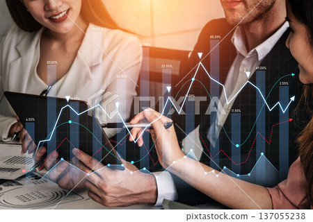 Business professionals analyzing financial data with tablet and graphs, discussing strategies and insights, office environment, teamwork concept Scalp 137055238
