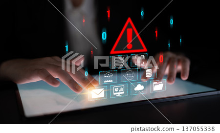Hands on Tablet with Digital Warning Sign and Symbols Representing Cybersecurity Risk and Data Protection Concepts in Dark Environment Quark 137055338
