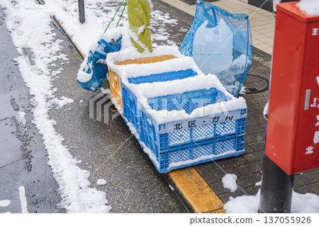 Snow-covered recyclable waste collection box - Winter street scene 137055926