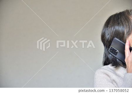 一位老年婦女正在用手機通話 一位老年婦女正在用手機通話 137058052
