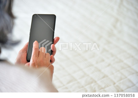 Senior woman operating mobile phone Senior woman operating mobile phone 137058058