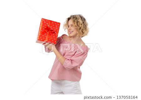Woman enjoys presenting a red gift box with a bow, isolated, PNG Woman enjoys presenting a red gift box with a bow, isolated, PNG 137058164