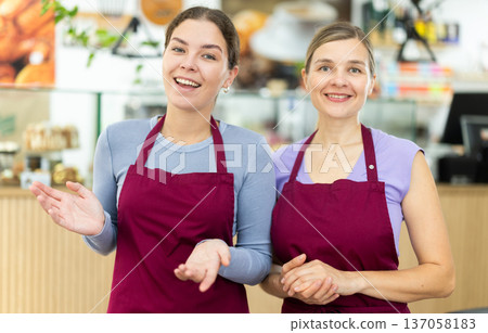 Two female cafe employee staff greets guests of establishment Two female cafe employee staff greets guests of establishment 137058183