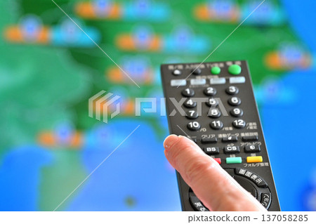 Senior woman operating a TV remote control 137058285
