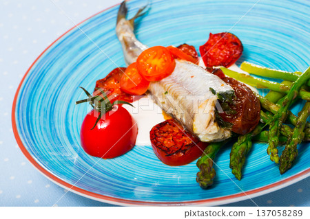 Baked whiting with sun-dried tomatoes, asparagus, creamy garlic sauce 137058289