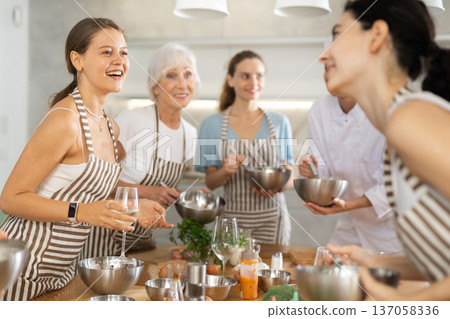 Young woman talks and drinks with group during master class 137058336