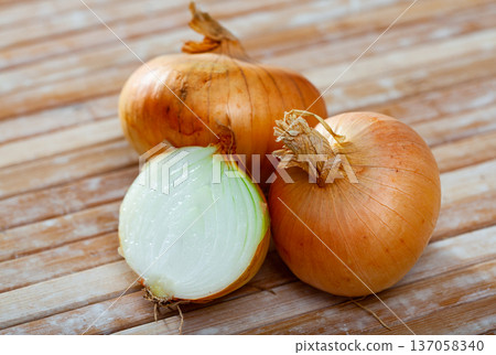 Ripe onions on wooden table Ripe onions on wooden table 137058340