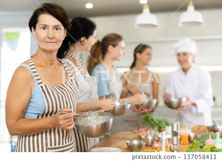 Mature woman holding bowl in her hands Mature woman holding bowl in her hands 137058411